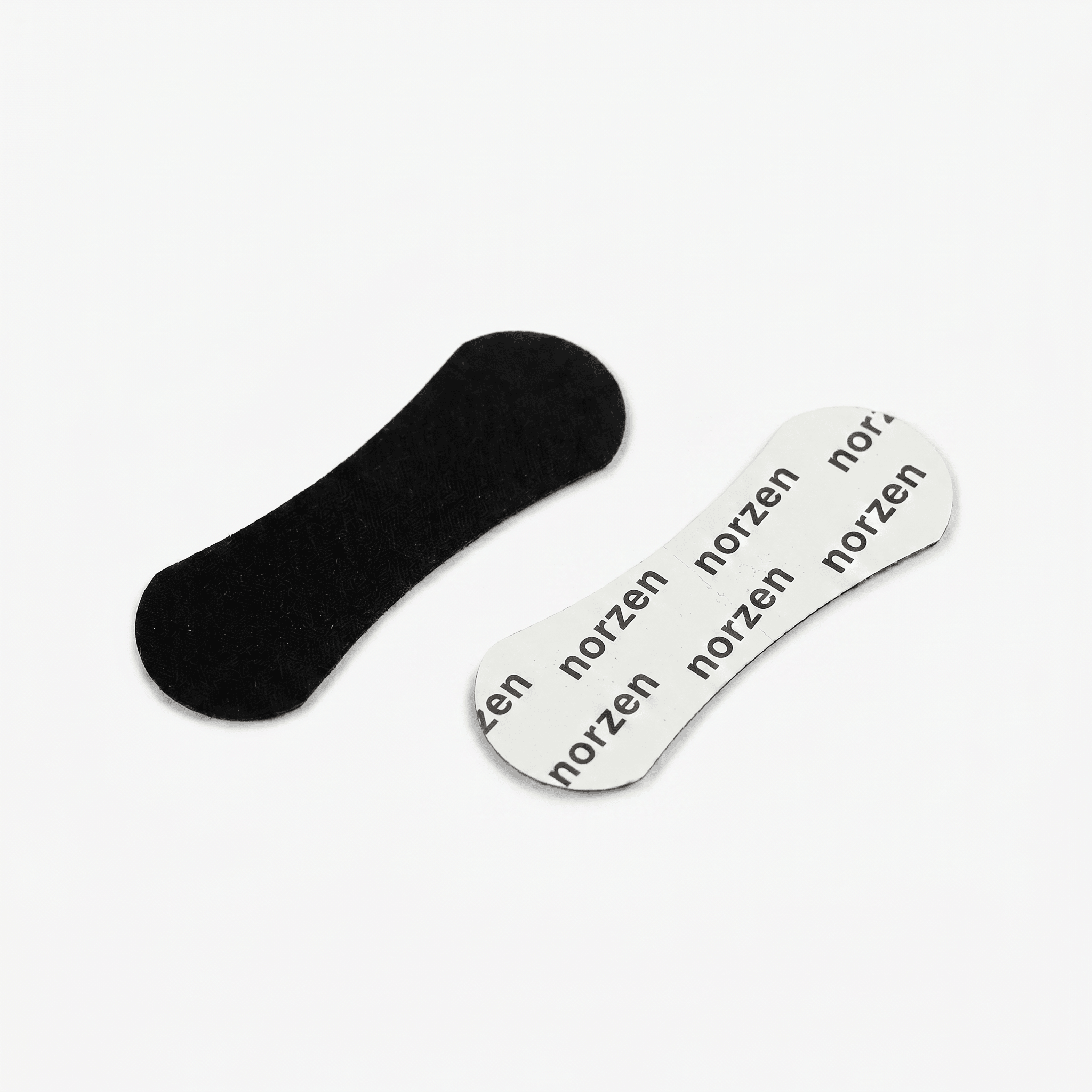 Svarte norzen nesestrips med minimalistisk design og hvit beskyttelsesfilm på lys bakgrunn.